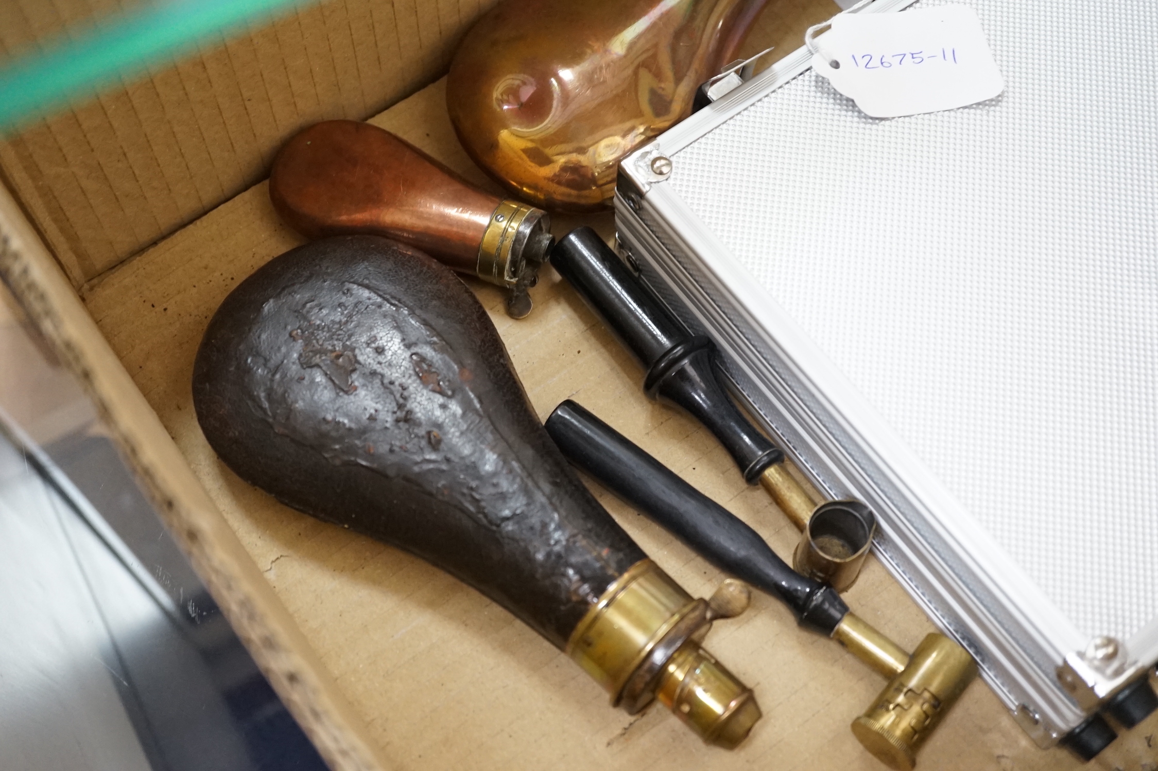 Three copper powder flasks, a leather powder flask, two powder measures and two cases of cleaning tools